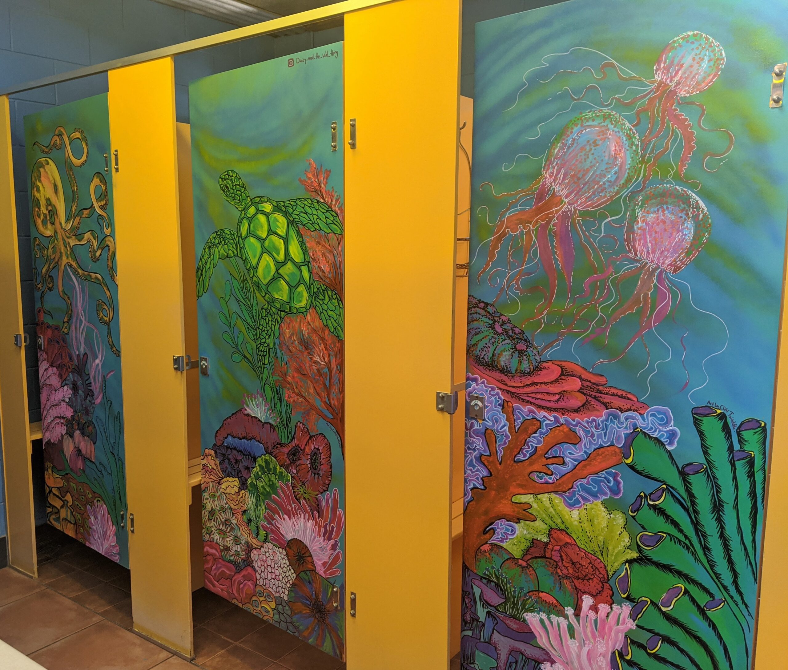 Depicts artwork created by volunteer staff in communal female bathroom